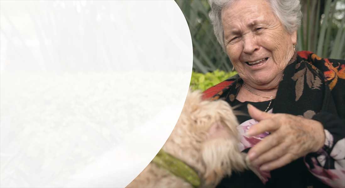 Image of older woman patting dog